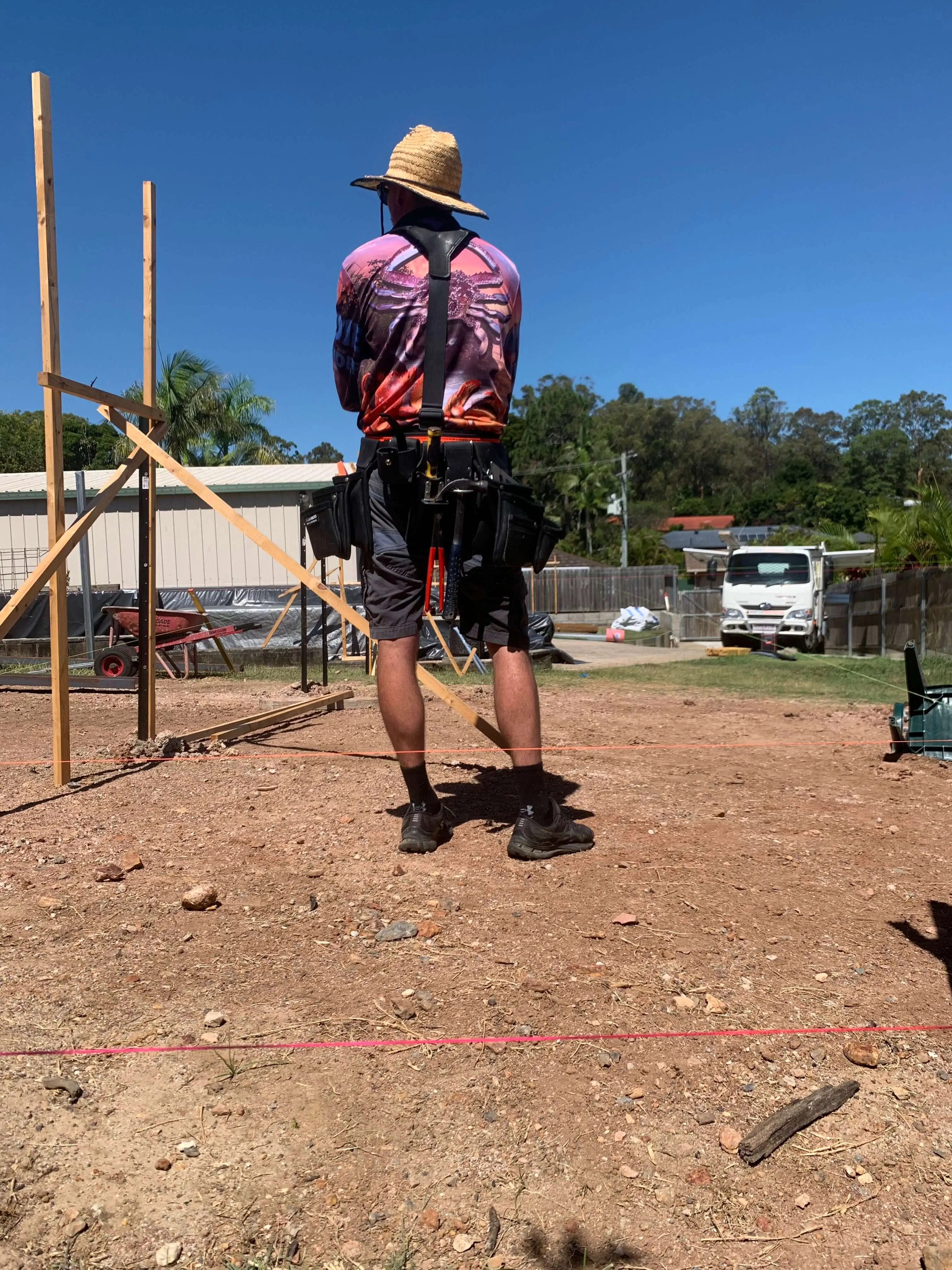 Carpenter checking string lines against setout profiles on a levelled site