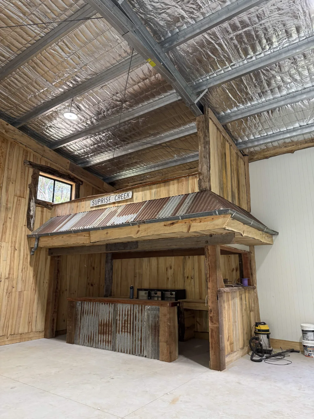 Custom bar with a corrugated iron awning and mezzanine above, Bayside Brisbane man cave