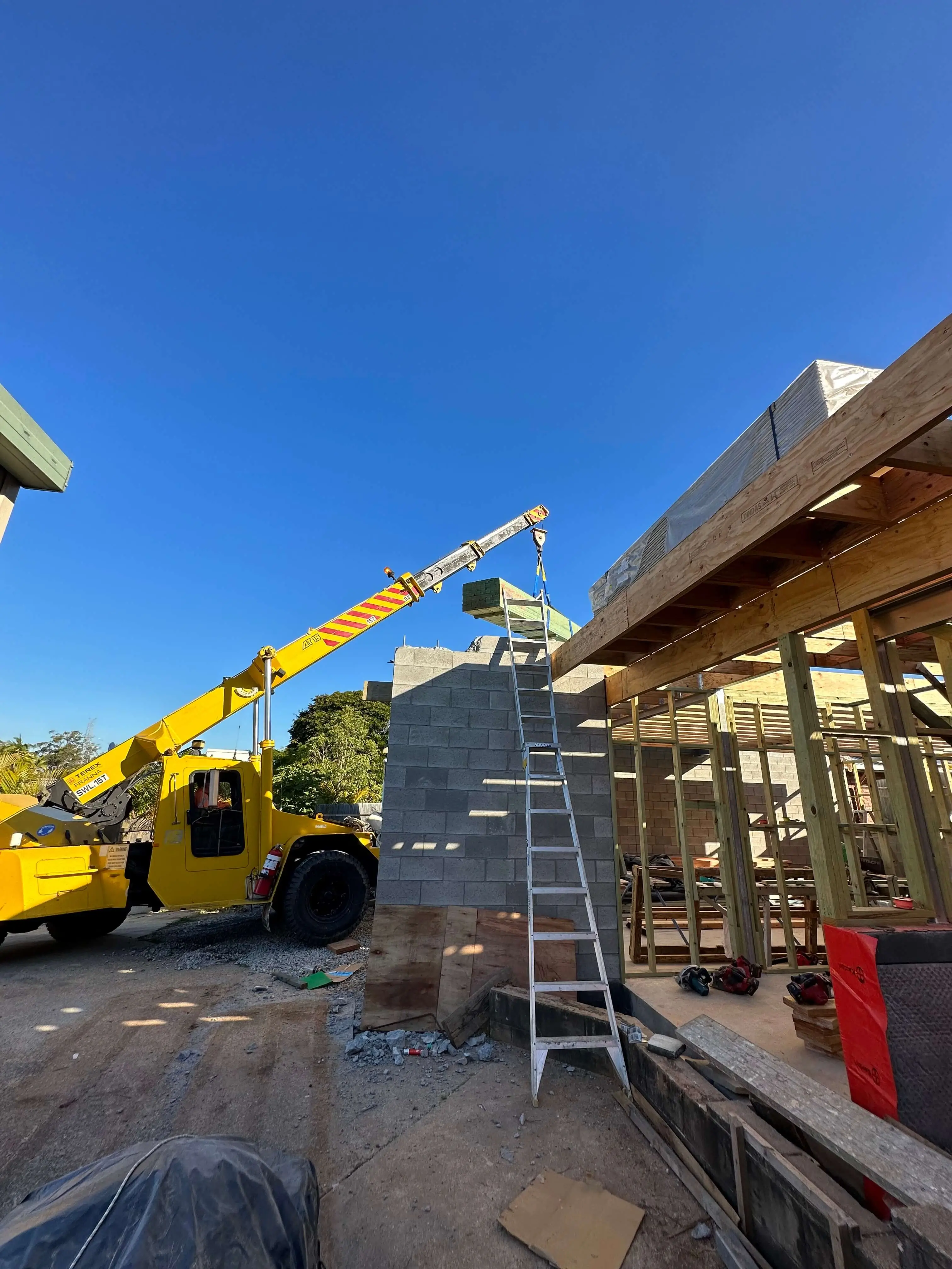 Terex Franna crane craning timber onto a blockwork wall on a two storey build