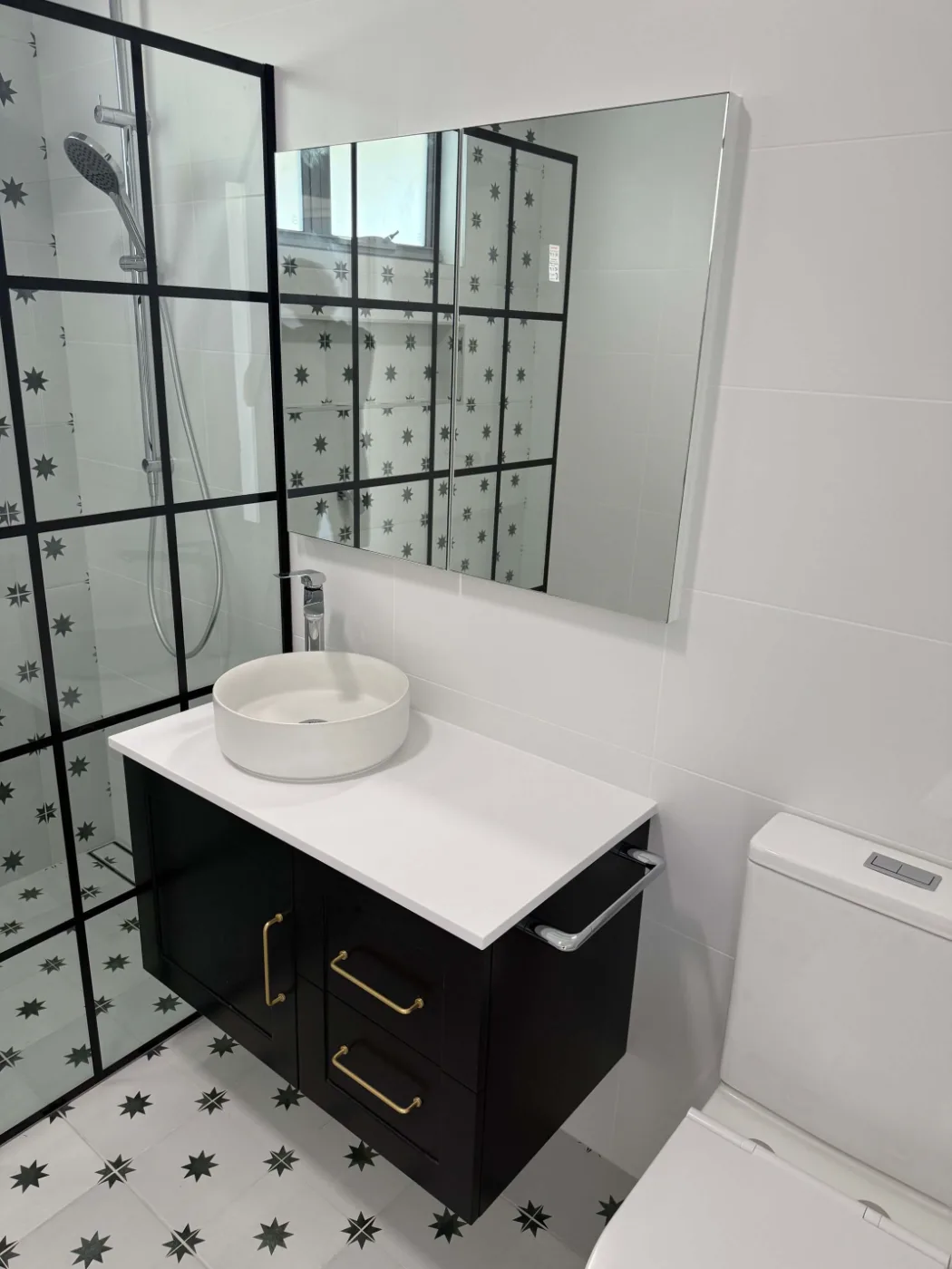 Black vanity with brass handles and patterned floor tiles, Brisbane bathroom renovation