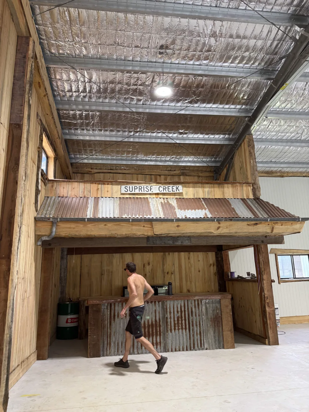 Builder working on a recycled timber bar build inside a Bayside Brisbane man cave