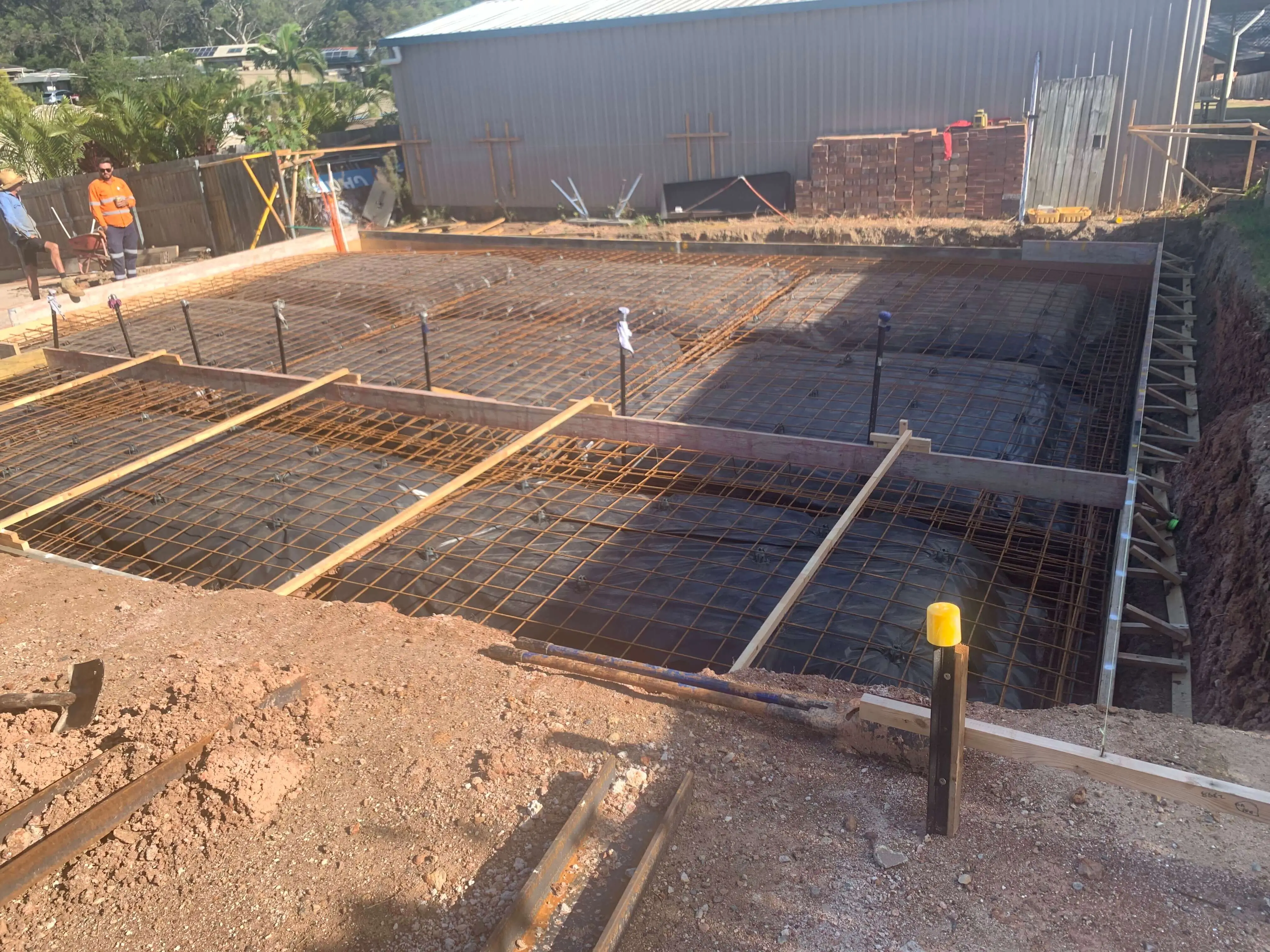 Reinforced slab formwork with mesh and plumbing penetrations ready for pour